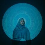 Woman in Blue Hijab Standing Beside Blue and White Wall